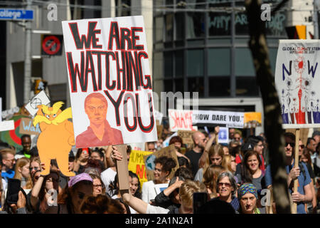 A demonstrator marches with a sign featuring Greta Thunberg during the Toronto Climate Strike with her 'How Dare You' quote visible on another sign. Stock Photo