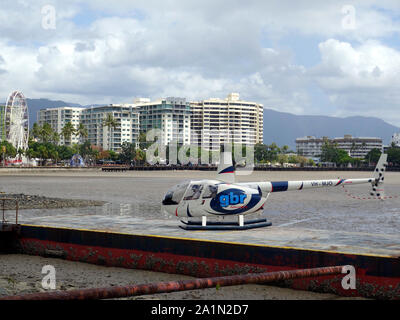 A tourist helicopter on an ocean pontoon at a low tide ready to takeoff with the newly installed fer Stock Photo