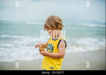 The boy cleans a banana Stock Photo