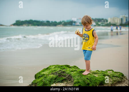 The boy cleans a banana Stock Photo