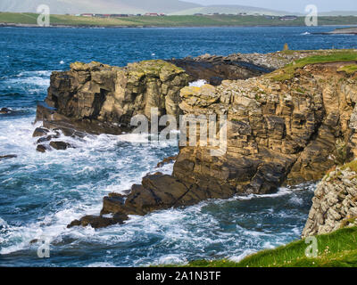 Wave action on inclined sandstone cliffs on the south Shetland coast near Sumburgh Head - the bedrock in this is the Bressay Flagstone Formation - san Stock Photo