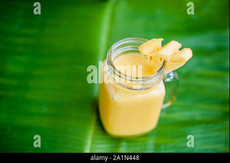 Pineapple cocktail with a slice of on banana leaf. Tropical concept Stock Photo