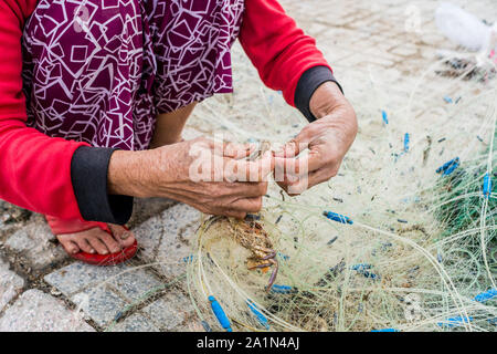 Hands of the old fisherman untangles fishing nets, Nha Trang Stock Photo