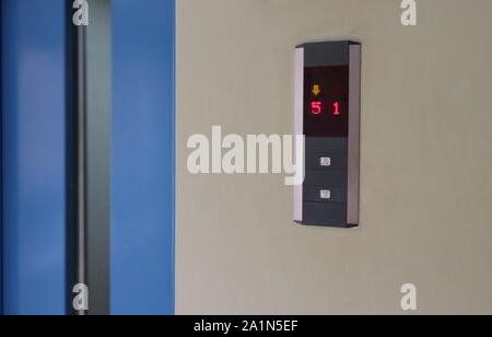 Closeup elevator button panel focus on  LED display. The elevator door is closing. Stock Photo