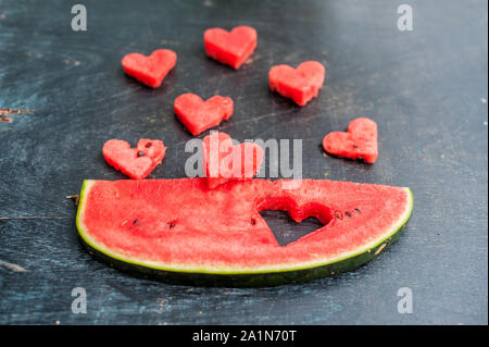 Piece of watermelon and hearts on the old wooden background. Flat lay Stock Photo