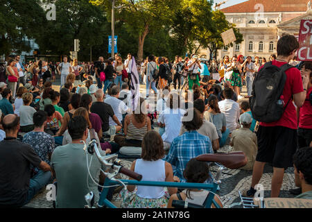 Lisbon, Portugal- 27 September 2019: Group of people sitting on the ground silently protesting against climate change Stock Photo