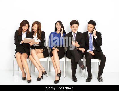 business people sitting on the chairs and using the smart phone Stock Photo