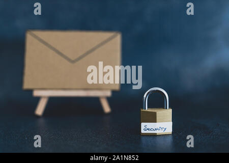 internet security and user privacy concept, email envelope miniature on easel with lock labelled security in front of it shot at shallow depth of fiel Stock Photo