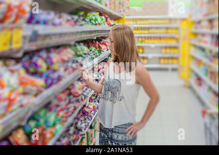 Beautiful young woman shopping for grocery products at a grocery store supermarket Stock Photo