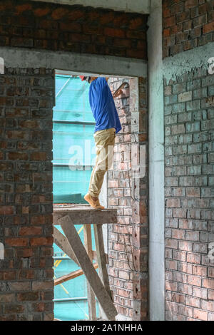 plasterer making up a brick wall vertical composition Stock Photo