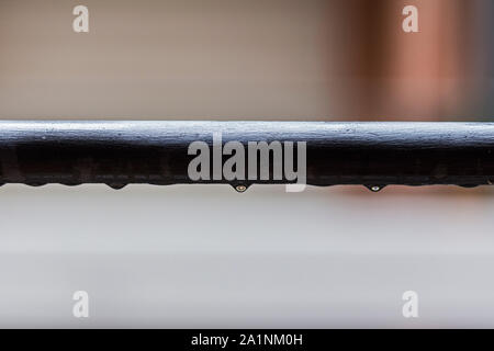 Rain water drops falling on a dark tube Stock Photo