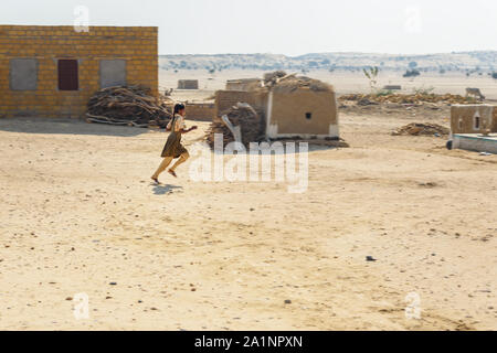 Jaisalmer, India - February 14, 2019: Indian girl runs in traditional village at Thar desert