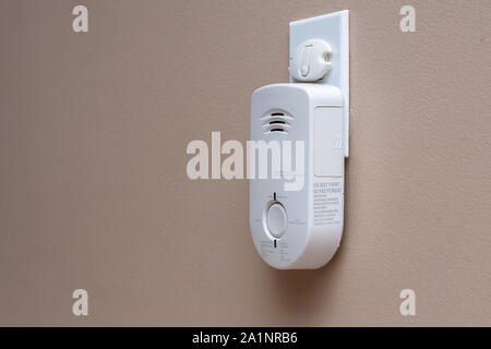 Carbon Monoxide (CO) monitor plugged into the wall of a residential house for safety. Stock Photo