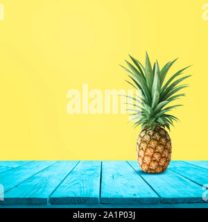 Pineapple on blue wood on yellow background.For montage product display or design keyvisual layout Stock Photo