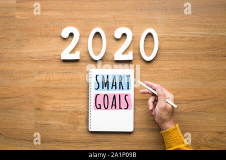 2020, smart goal concepts with notepad and male hand on wood background.Business challenge.Inspiration ideas.Human performance Stock Photo