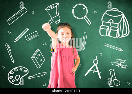 little girl standing against chalkboard and education  concept Stock Photo