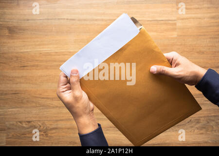 Male holding paper envelope, letter on floor wood. business concepts ideas Stock Photo