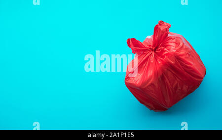 Food trash packing in red plastic bag on blue color background. Recycle and environment concepts ideas Stock Photo