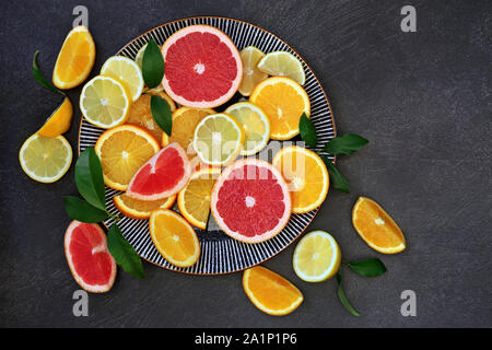 Winter sunshine health food of citrus fruit with oranges, lemons and grapefruits on a round plate. Super foods high in antioxidants and vitamins. Stock Photo