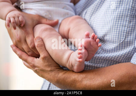 A dad holds a baby in his arms Stock Photo