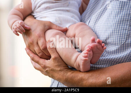 A dad holds a baby in his arms Stock Photo