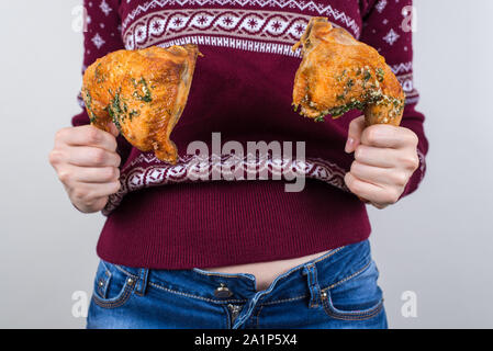 Trash food concept. Cropped close up photo of satisfied feeling good after party event birthday holding two pieces of food in hands isolated grey back Stock Photo