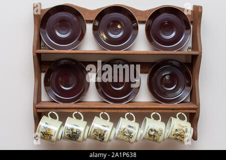 Dutch mugs and plates hanging on a rustic wooden frame on the wall. Culture of Holland in the Netherlands. Common in homes. Stock Photo
