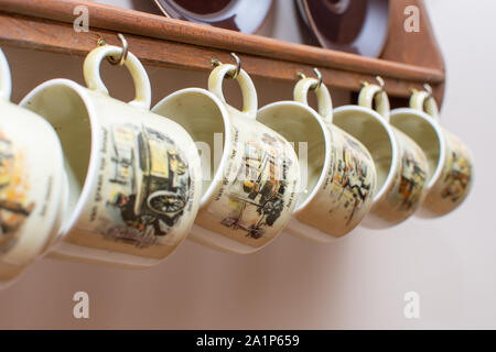 Dutch mugs and plates hanging on a rustic wooden frame on the wall. Culture of Holland in the Netherlands. Common in homes. Stock Photo