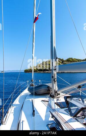 Sailing boat near Croatian island Lastovo. View from the deck of the yacht. Czech flag on the boat. Sailing on the sea. Stock Photo