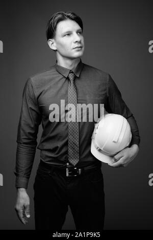 Businessman with hardhat against shot in black and white Stock Photo