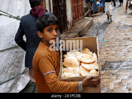 Sanaa, Yemen. 28th Sep, 2019. A Yemeni child carries a box of bread for sale at a market in Sanaa, Yemen, Sept. 28, 2019. The UN Children's Fund (UNICEF) announced Wednesday that 2 million Yemeni children are out of school, including almost half a million who dropped out since the conflict escalated in March 2015. Credit: Mohammed Mohammed/Xinhua/Alamy Live News Stock Photo