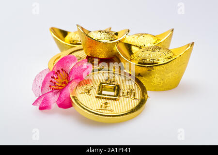 Close up view of Gold ingots of various size and Chinese Emperor's coins  on white surface Stock Photo