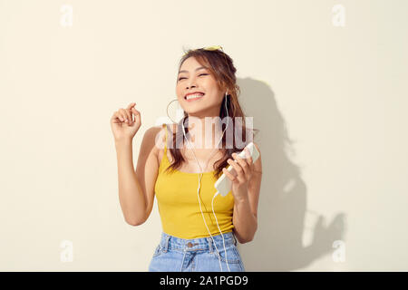 Asian Woman dancing with mobile phone on the white background Stock Photo