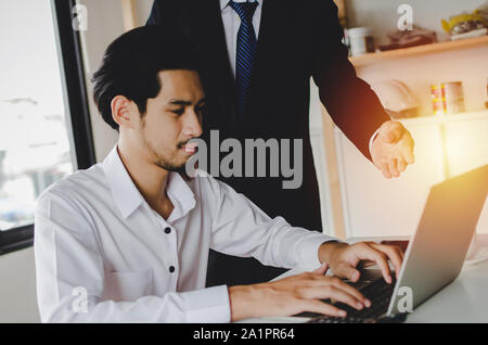Job training. new manager boss mentor teaching online work to young intern man apprentice learning, working on laptop computer at home office Stock Photo