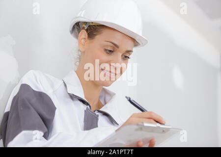 female builder writing on a clipboard Stock Photo