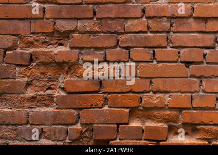 background old brick wall of jagged red clay bricks Stock Photo