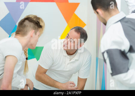 teacher talking to students in painting and decorating class Stock Photo