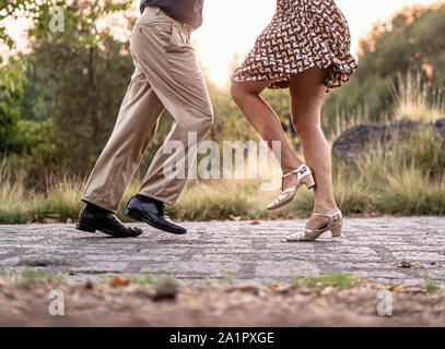 Two adult dancers feet dancing swing music outdoors in the park - unrecognizable people Stock Photo