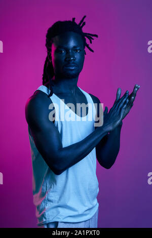 young dancer clapping his hands, applouding, afro guy with stylish dreads rubbing his palms Stock Photo