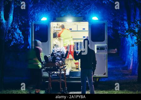 Doctor and paramedic of emergency medical service take care of old ill man. Team of emergency medical service rescuing old patient. Concepts health ca Stock Photo