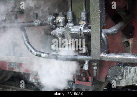 Close up of pipes of engine on old romanian steam engine train from Resita corporation. With steam coming out downwards Stock Photo