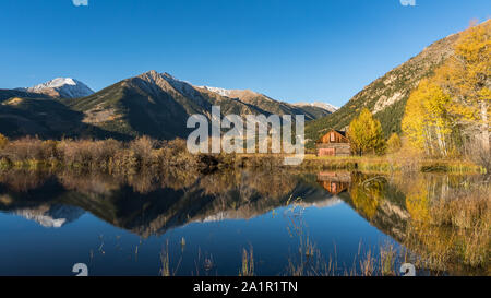 Old cabin by lake in Autumn colors Stock Photo