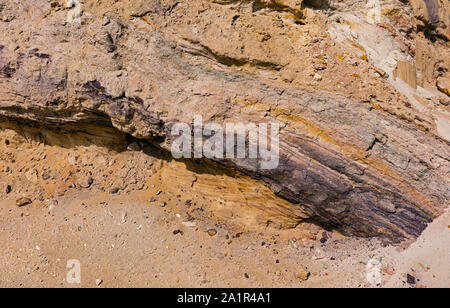 layers of soil and rock exposed by road building on in makhtesh ramon near Mitspe Ramon in Israel showing strata of various colors and textures Stock Photo