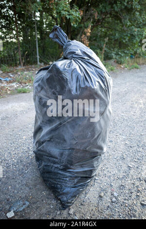 illegally disposed black bin bag in landscape Stock Photo