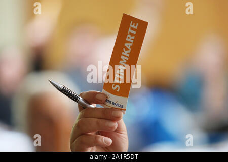 Rostock, Germany. 28th Sep, 2019. A member of the Free Voters Party of Mecklenburg-Western Pomerania is holding a voting card in the conference hall of the Trihotel. At the state party conference, the free voters of Mecklenburg-Western Pomerania elected their new executive committee. Credit: Danny Gohlke/dpa/Alamy Live News Stock Photo
