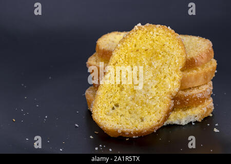 Delicious crisp sliced butter toast on black plate Stock Photo