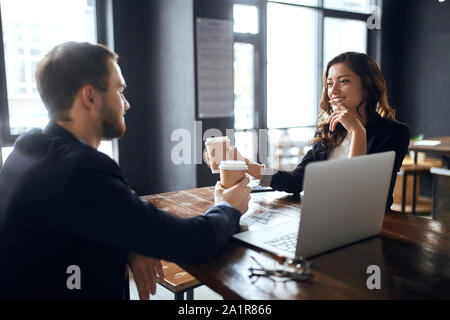 Cheerful office workers holding disposable cups of tea, having a rest after working day. close up photo. colleagues celebrating successful contract. h Stock Photo