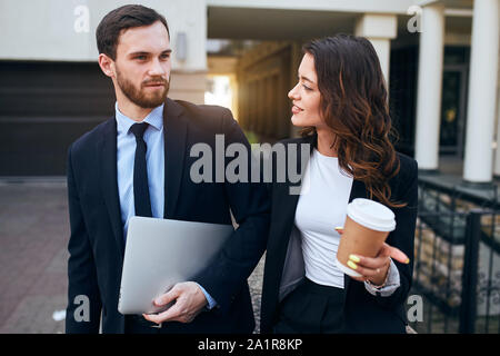 attractive man and woman in stylish suits talking after working day. close up photo. conversation.pleasant pastime Stock Photo