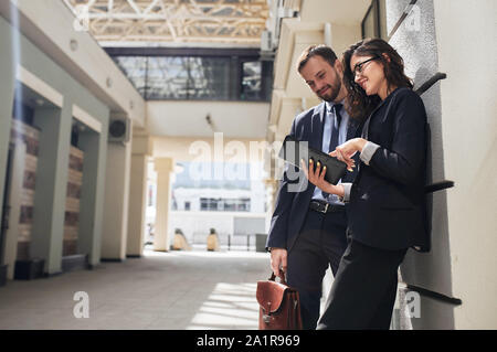 Business cheerful young people using electronic tablet, during meeting outside, technology concept. close up photo. copy space Stock Photo