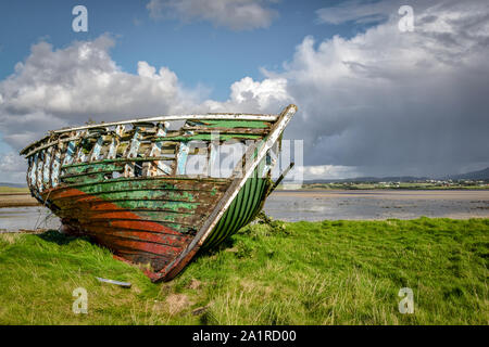 An old wooden Fishing boat decaying on a beach in Donegal Ireland